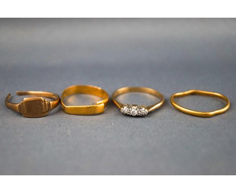 A collection of yellow metal rings to include: A three stone diamond ring, stamped 18ct &amp; PT, Size P; Three mis-shapen/br