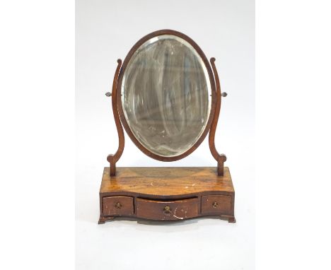 A George III mahogany swing frame mirror on serpentine box base with three freeze drawers on ogee bracket feet, 58cm high, 42