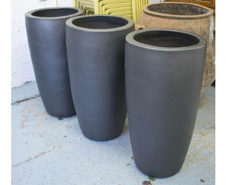 PLANTERS, a set of three, in black painted ceramic, 47cm diam x 90cm H. (3)