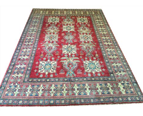 FINE KAZAK CARPET, 266cm x 185cm, row of geometric medallions on a ruby field within multiple complimentary bands and borders