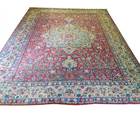 FINE ANTIQUE PERSIAN KERMAN LAVER CARPET, 358cm x 264cm, pendant medallion on a ruby field of palmettes and vines within comp