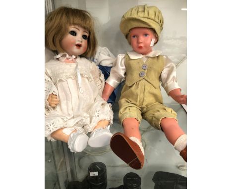 A KAMMER AND REINHARDT 22 BISQUE HEADED DOLL TOGETHER WITH A PLASTIC DOLL