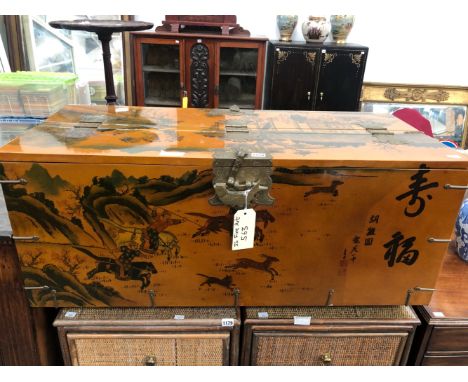 A CHINESE AMBER GROUND LACQUER TRUNK PAINTED WITH A HUNT AND A VILLAGE SCENE.   W 105 x D 47 x H 46cms.