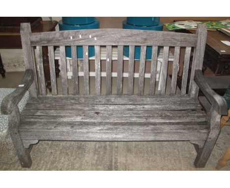 Weathered probably teak set of garden furniture to include; two elbow chairs, open arm bench and table. (4) (B.P. 21% + VAT)I