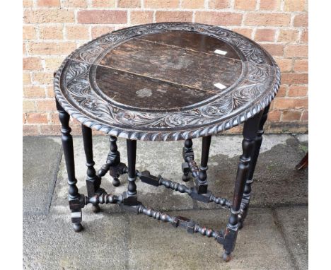 19TH CENTURY OAK GATELEG TABLE, the top with carved scroll and floral decoration surround, raised on circular legs with stret