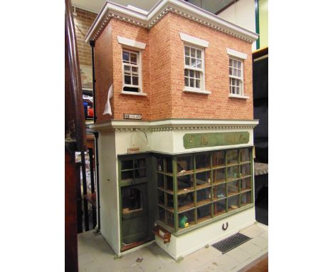 A 1/12 SCALE DOLL'S ANTIQUE SHOP  of sectional medium density fibreboard and wooden construction, the ground floor retail are