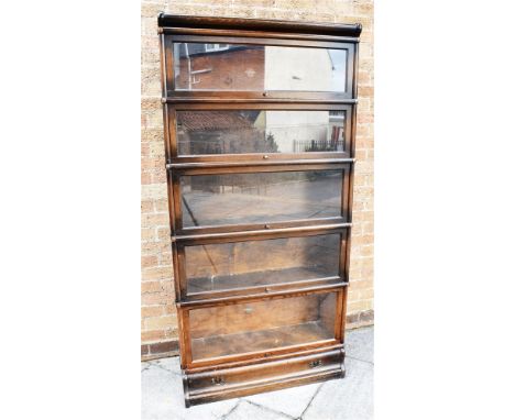 GLOBE WERNICKE OAK FIVE SECTION BOOKCASE, with cornice above five sections of which two bear a makers stamp, raised on a plin