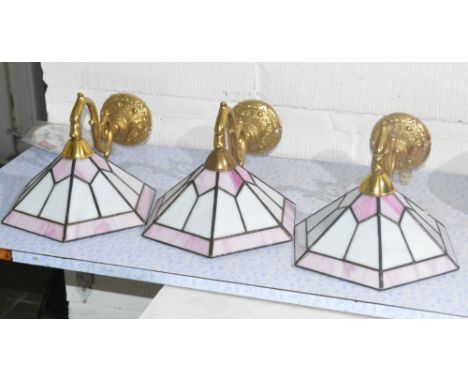 Three scrolling wall lights with Tiffany style leaded glass lamp shades.