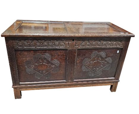 Antique oak coffer, the two panel hinged lid over a frieze carved with fleur-de-lys and initialled TB, the two panels carved 