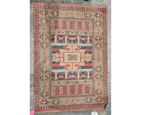 Turkish red ground rug with central hooked geometric medallion on striped field, single elephant foot gul border and multiple