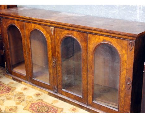 A Victorian burr walnut low bookcase with glazed arch panel doors (distressed). W224cm D50cm H104cm