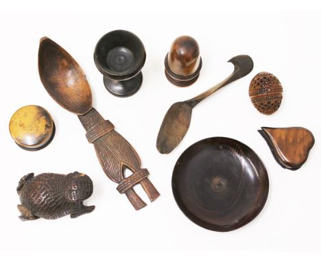A mixed lot of treen comprising two spoons, a frog snuff box, an egg cup, a tray dish, a carved cocquilla nut etc.