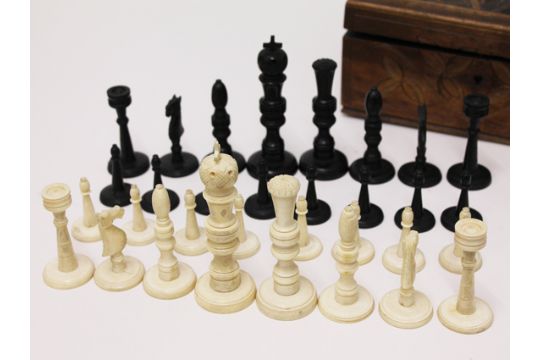 An Ivory And Ebony Chess Set With Carved Box