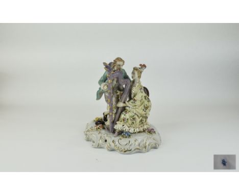 German Late 19thC Handpainted Porcelain Group Figure of a Male and Female in 18thC Dress playing a harp on a floral base. Mar