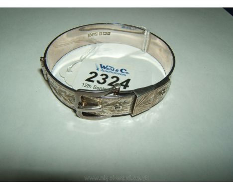 A narrow silver belt style bangle with engraved decoration.