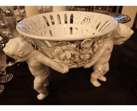 Ceramic table bowl held up by three cherubs 