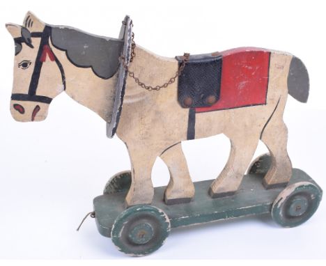 A Wooden Painted Cut Out Model of a Shire Horse pull along toy, mounted on wheels, with applied paper label to base ‘Made by 