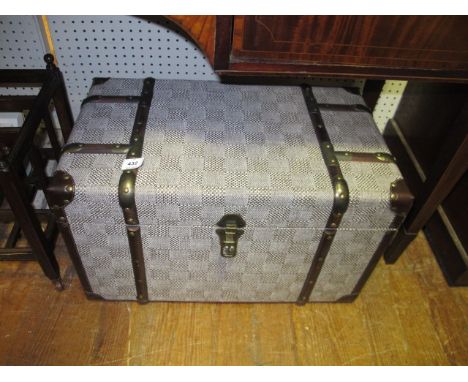 A SMALL UPHOLSTERED TRAVELLING TRUNK with strap hinges