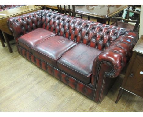 A VICTORIAN STYLE HIDE UPHOLSTERED LIBRARY COUCH with deep button upholstered back and arms with loose cushions 188cm wide