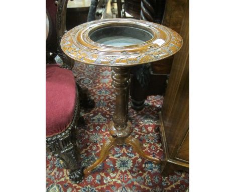 A CONTINENTAL WALNUT JARDINIERE STAND the circular carved top above a baluster column on tripod support with scroll toes 73cm