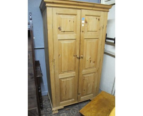 A PINE TWO DOOR WARDROBE with panelled doors on ogee bracket feet 191cm (h) x 100cm (w) x 53cm (d)