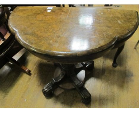 A VICTORIAN WALNUT FOLD OVER CARD TABLE the shaped moulded top above a leaf capped column platform base with splayed legs on 