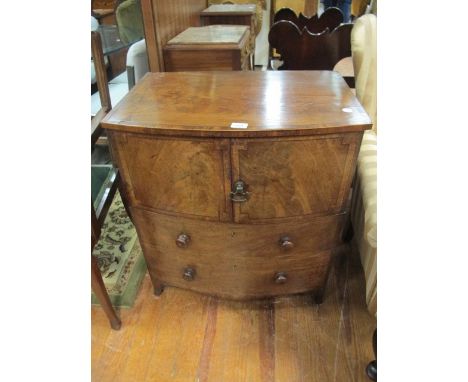 A GEORGIAN MAHOGANY BOW FRONT CHEST with cupboard above two graduated drawers 69cm wide