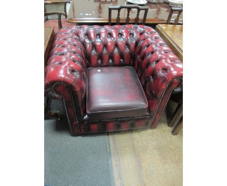 A HIDE UPHOLSTERED LIBRARY CHAIR with deep button upholstered back and arms with loose cushion