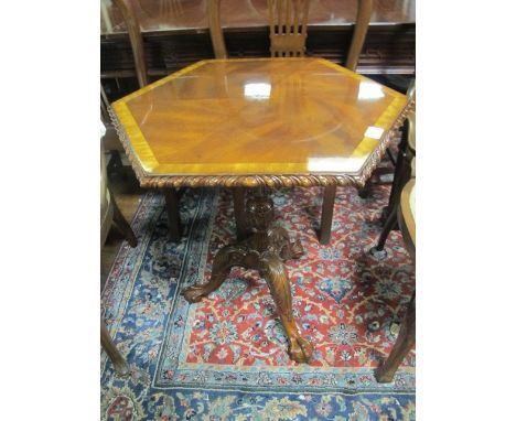 A MAHOGANY AND SATINWOOD CROSS BANDED OCCASIONAL TABLE of octagonal outline with gadrooned rim above a baluster column on tri