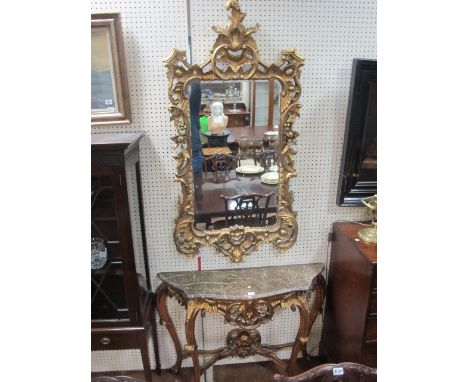 A GILT CONSOLE TABLE with ornate frieze and grey mottled top 110cm wide together with a matching ornate bevelled glass mirror