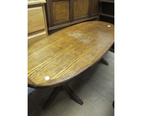 AN OAK COFFEE TABLE the oval top raised on tripod base joined by a cross stretcher