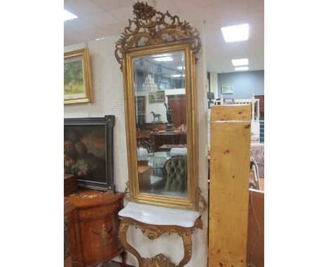 A GILT SCROLL LEG CONSOLE TABLE with moulded decoration and mottled marble top together with a matching upright gilt mirror w