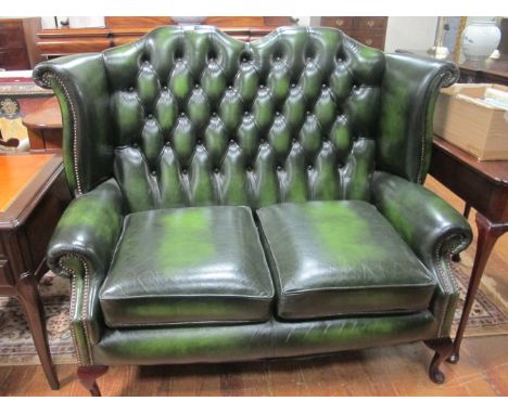 A GOOD GREEN LEATHER UPHOLSTERED BUTTON BACK TWO SEATER SETTEE with brass studding and cabriole legs