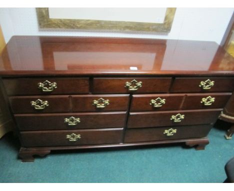 A MAHOGANY LOWBOY the rectangular top above an arrangement of seven drawers with brass drops handles on ogee bracket feet