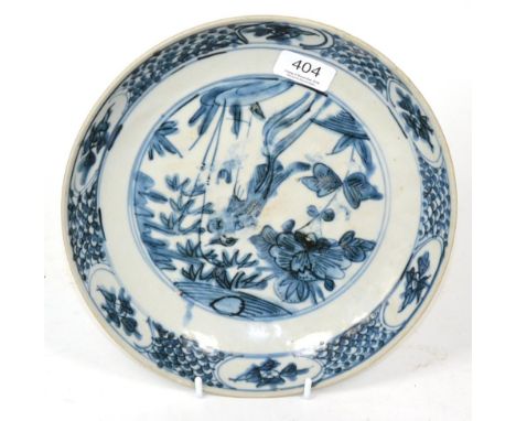 A Swatow porcelain saucer dish, probably 17th century, painted in underglaze blue with a phoenix amongst peony and bamboo wit