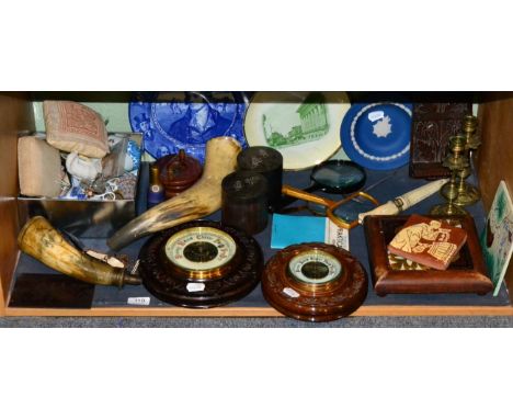 A shelf of collectors items including a quantity of miniature ceramics; two horn powder flasks; two aneroid barometers; two e