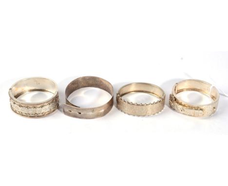 A Victorian silver cuff bangle, the front applied buckle motif, another Victorian silver cuff bangle with applied decoration 