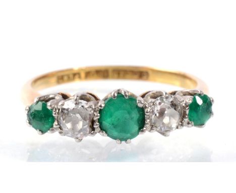 An emerald and diamond half hoop ring, three graduated round cut emeralds, spaced by old cut diamonds, total estimated diamon