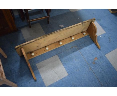 A Pine Wall Shelf, with Five Ceramic Coat Hangers, 112cms Wide 