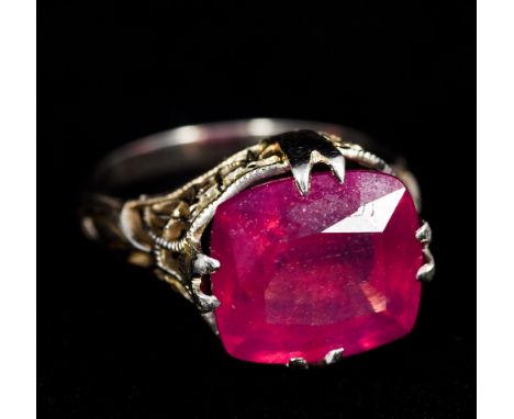 An 18 K white gold single stone ring, possibly rubyThe facet cut stone set above pierced shoulders.   CONDITION REPORTS:  Gen