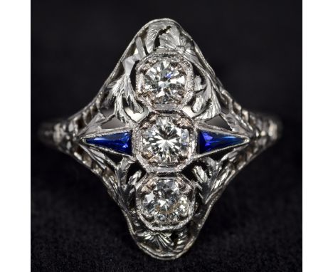 An Art Deco style platinum, diamond and sapphire set ringOf pierced domed navette form, the central stone approximately 0.25 