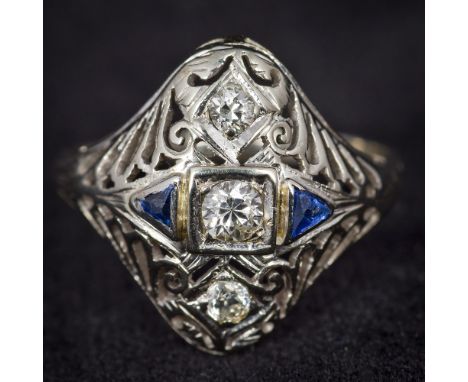 An Art Deco style 18K  white gold diamond and sapphire set ringOf pierced domed navette form.  1.75 cm wide.    CONDITION REP