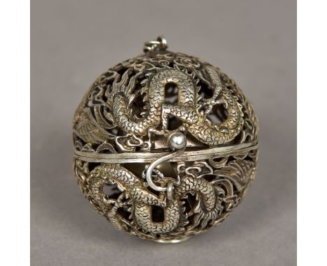 A Chinese white metal pendant incense burnerOf pierced globe form, worked with dragons, phoenixes and flaming pearls, enclosi