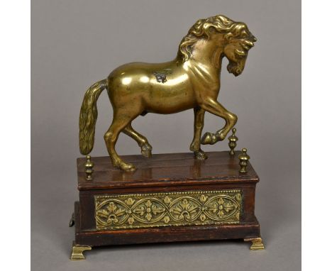 An antique, possibly early 18th century, brass figure of a horseModelled standing on a brass inset wooden plinth base with br