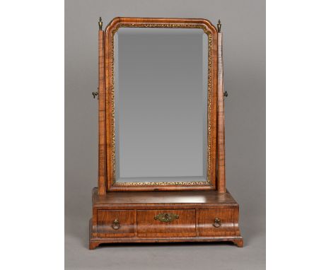 A George III walnut toilet mirrorWith bevelled plate and three curved frieze drawers, standing on bracket feet.  38 cm wide. 