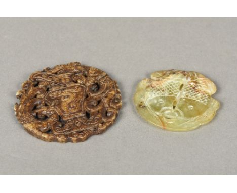 Two carved and pierced jade roundelsOne worked with mythical beasts flanking an ewer, the other worked with a pair of carp.  