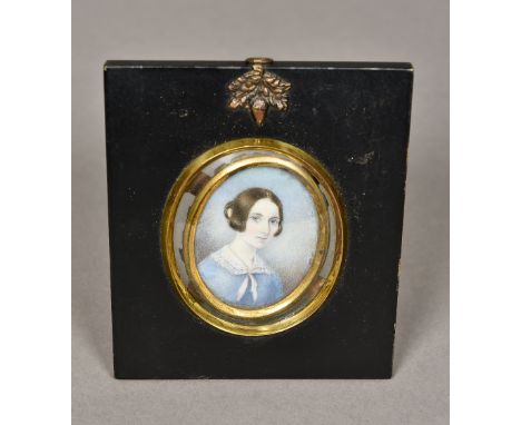 A framed miniature portrait on ivoryDepicting a young girl wearing a pink collared blue dress, framed and glazed.  10.5 x 12.