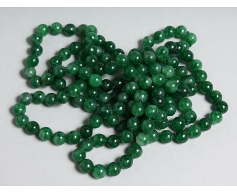 A STRING OF JADE BEADS 52ins long.