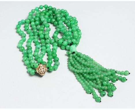 A LONG STRING OF JADE BEADS with 18ct and diamond clasp.