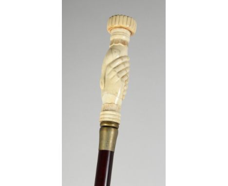 A CARVED BONE HANDLE WALKING STICK "CLENCHED FIST". 36ins long.